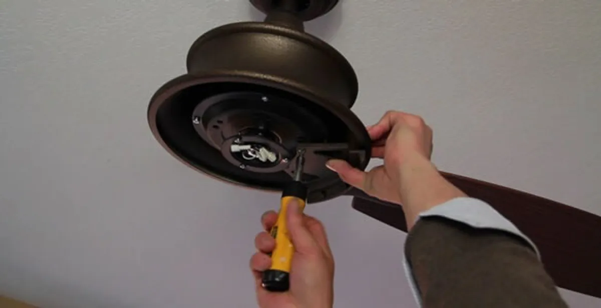Electrician installing ceiling fan mounting bracket and fixture in Grand Rapids, MI