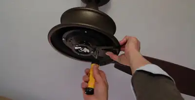 Electrician installing ceiling fan mounting bracket and fixture in Grand Rapids, MI