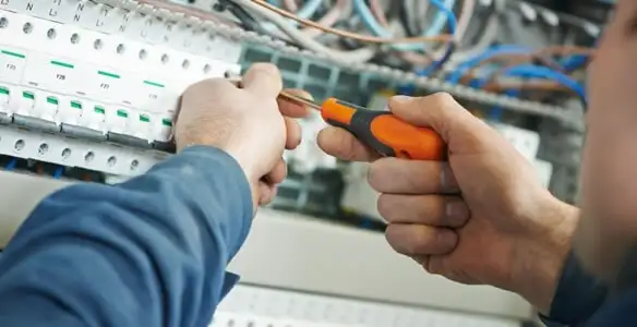 electrical service showing licensed electrician performing electrical panel maintenance and adjustments in Grand Rapids, MI