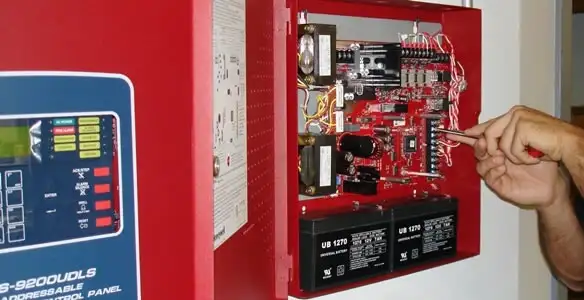 fire alarm installation service showing technician configuring fire alarm control panel in Grand Rapids, MI