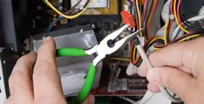 Licensed electrical contractor performing electrical repair with tools in Grandville, MI