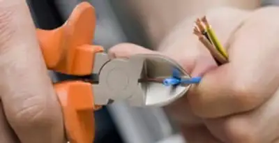 professional electrical services showing precise wire cutting by licensed electricians in Grand Rapids, MI