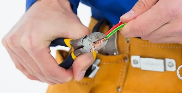 licensed electrician securing electrical wiring with professional tools during service work in Grand Rapids, MI