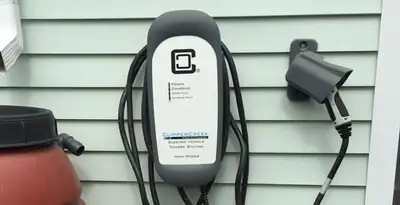 Outdoor electric vehicle charger installation on residential wall in Grand Rapids, MI